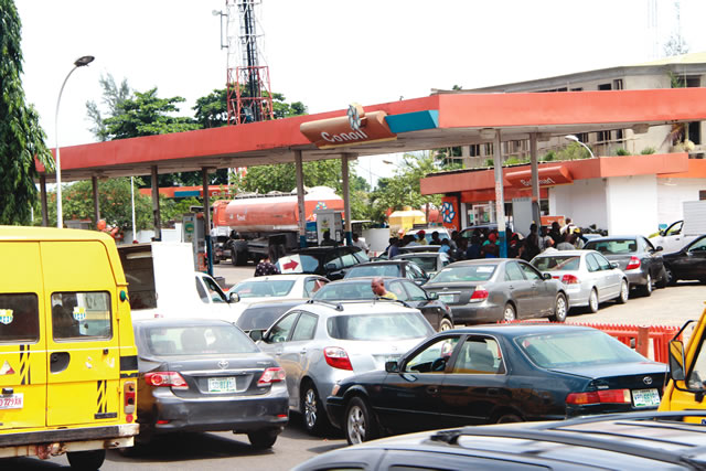 Image result for :People queueing at a fuel station, in Lagos .... last year. Photo: Saheed Olugbon